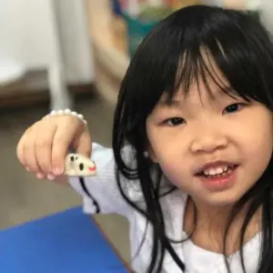 Kindergarten 1 child holding a craft item during inquiry-based learning
